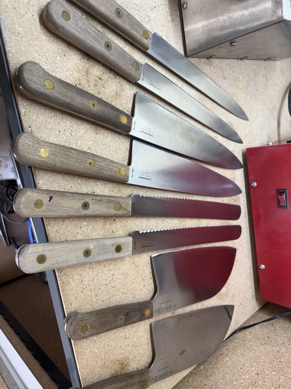 A set of our clients knives spread out on a table.