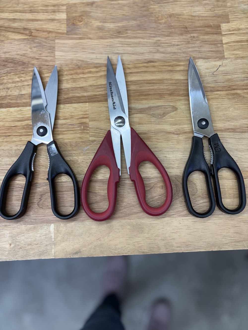Set of scissors from a customer - 3 scissors laying on a table.