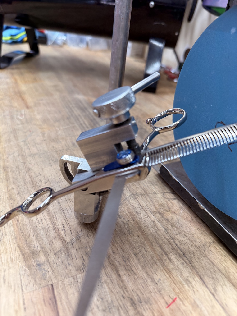 Shears in a vice being pressed into a shear sharpening machine.